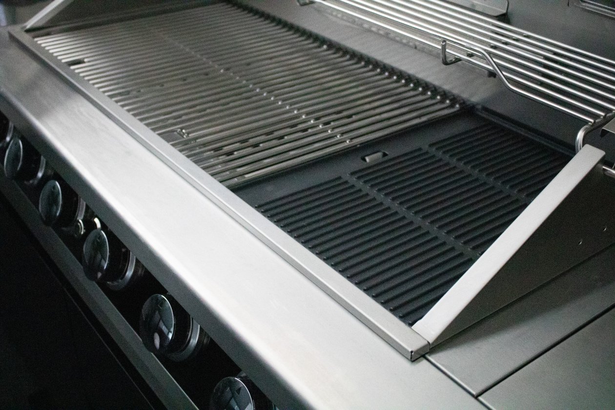 Översiktsbild över grillens rymliga insida med robusta grillgaller och varmhållningshylla, redo för matlagning i toppklass.